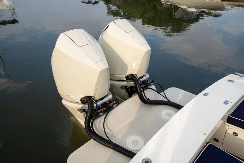 Slide: The Image of Twin outboard engines on a 2021 Brooklin Boat Yard 32 Express, docked on calm water. - 7