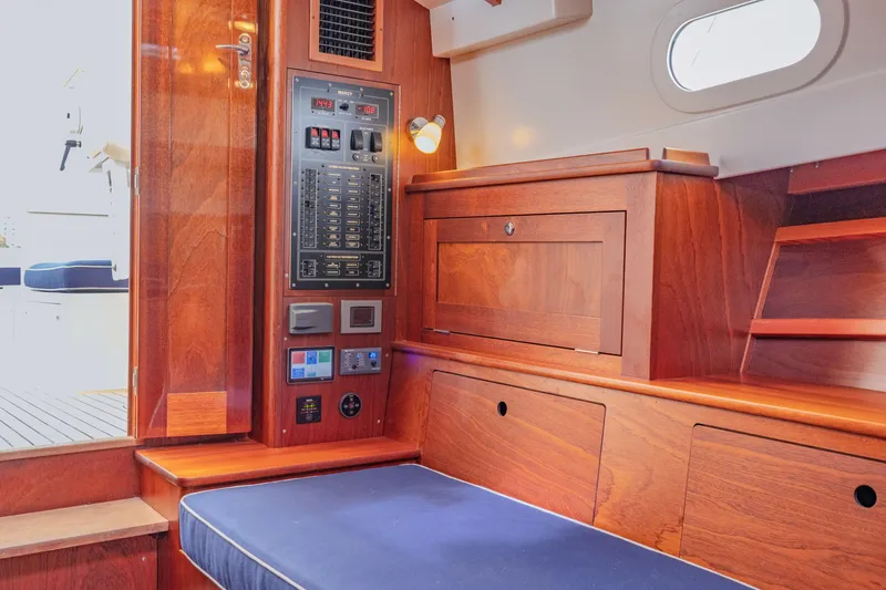 Slide: The Image of Interior of 2021 Brooklin Boat Yard 32 Express, featuring wooden cabinetry and control panel. - 24