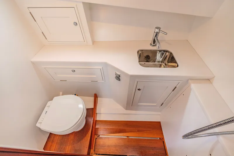 Slide: The Image of 2021 Brooklin Boat Yard 32 Express bathroom with sink, toilet, and wooden flooring. - 27