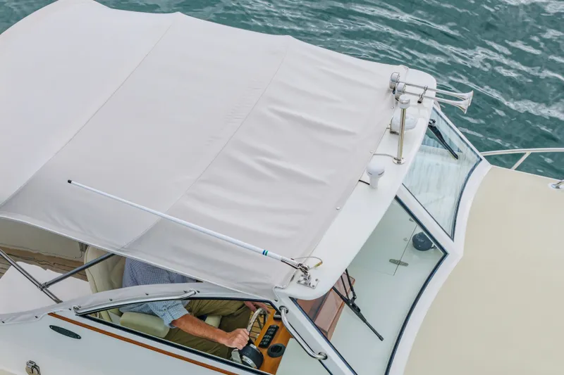 Slide: The Image of 2021 Brooklin Boat Yard 32 Express cruising on water, top view of helm and canopy. - 33