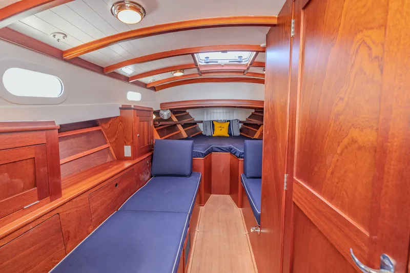 Slide: The Image of Luxurious 2021 Brooklin Boat Yard 32 Express cabin with elegant wood finish and blue seating. - 20