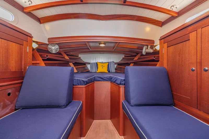 Slide: The Image of Luxurious 2021 Brooklin Boat Yard 32 Express cabin with wooden interior and navy cushions. - 21