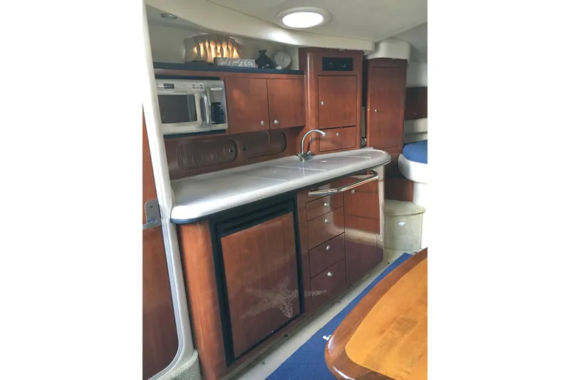 Slide: The Image of 2007 Sea Ray 340 Sundancer interior kitchen with wood cabinets and modern appliances. - 23