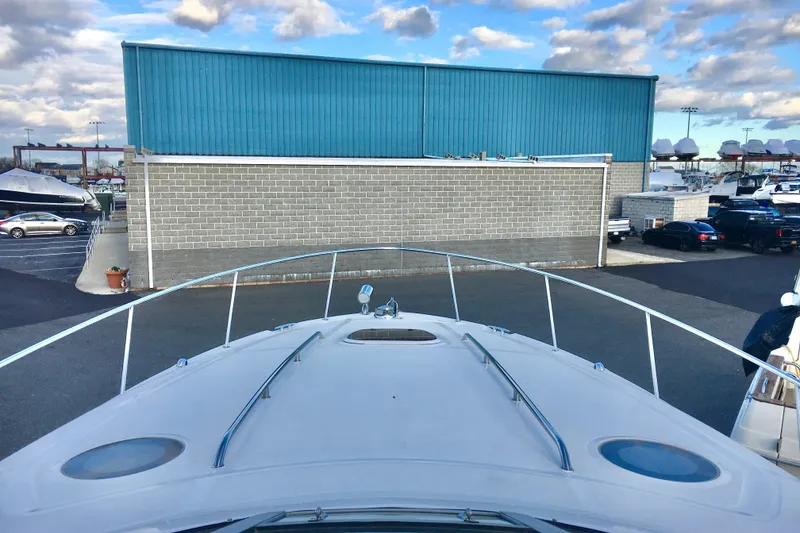 Slide: The Image of 2007 Sea Ray 340 Sundancer yacht docked near a blue warehouse under a cloudy sky. - 4