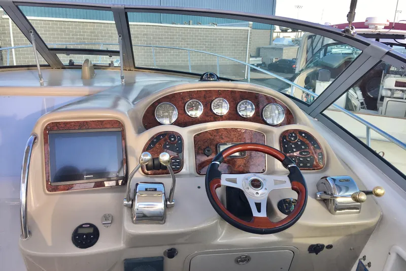Slide: The Image of 2007 Sea Ray 340 Sundancer helm with wood accents and modern controls. - 8
