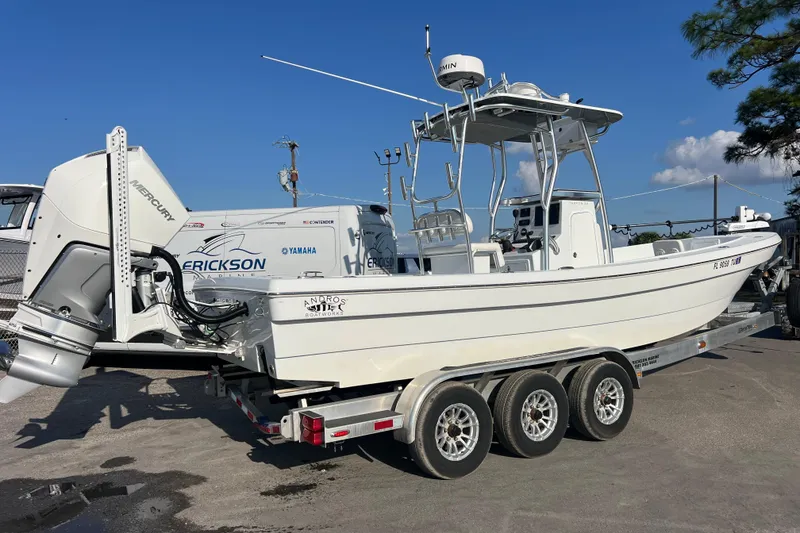 Slide: The Image of 2024 Andros Tarpon 26 boat on trailer, featuring Mercury engine, clear sky background. - 4