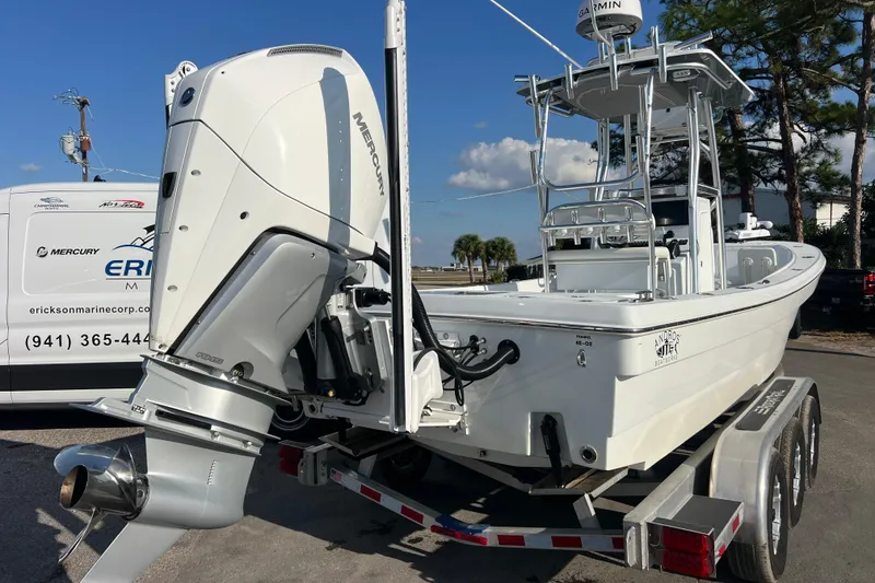 Slide: The Image of 2024 Andros Tarpon 26 boat on trailer with Mercury outboard engine, parked outdoors. - 5