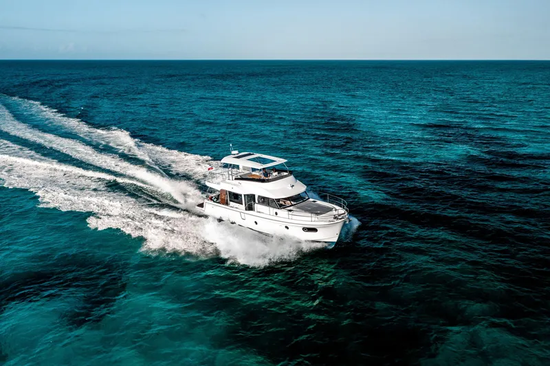 Slide: The Image of 2026 Beneteau Swift Trawler 48 cruising on clear blue ocean waters. - 15