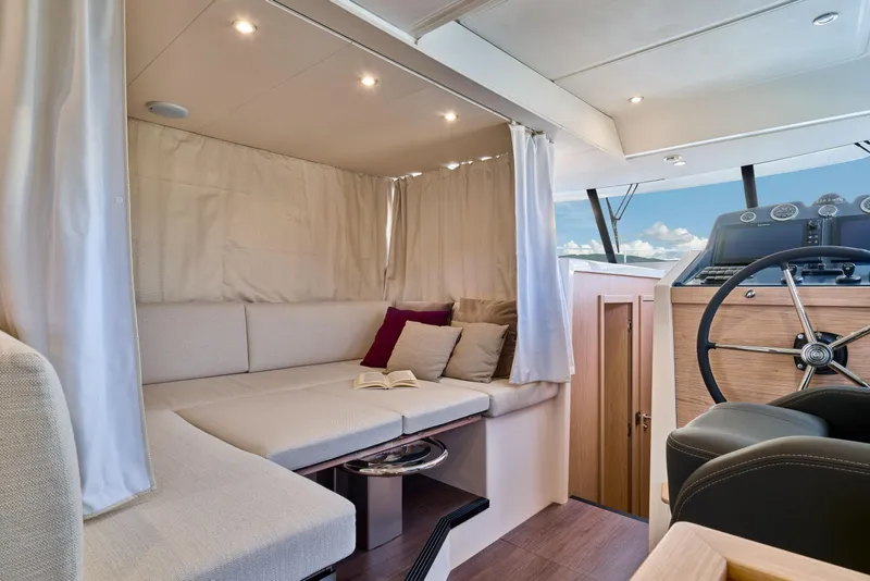 Slide: The Image of Interior of 2026 Beneteau Swift Trawler 48, featuring cozy seating and helm station. - 28