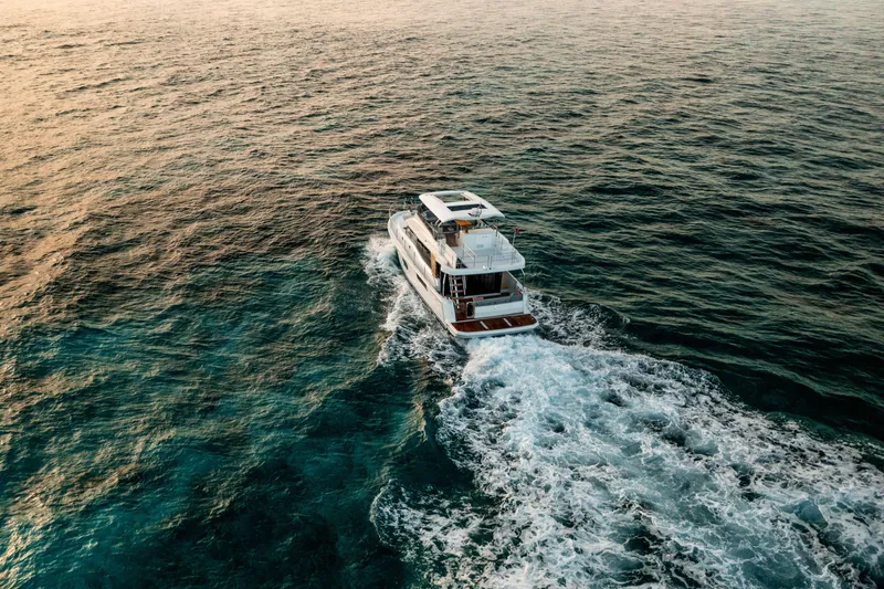 Slide: The Image of 2026 Beneteau Swift Trawler 48 cruising on open sea at sunset. - 5