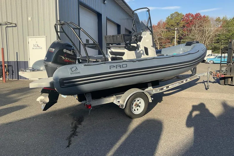 Slide: The Image of 2020 Zodiac Pro 5.5 boat on trailer, parked outside a marine facility. - 2