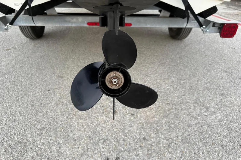 Slide: The Image of Close-up of a 2023 Mako Pro Skiff 15 CC boat propeller on a textured surface. - 11