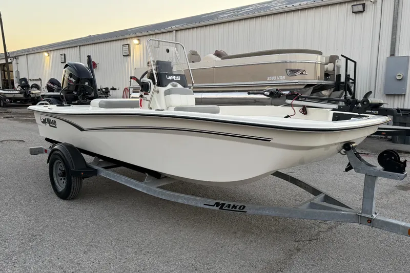 Slide: The Image of 2023 Mako Pro Skiff 15 CC boat on trailer, parked outdoors at sunset. - 17