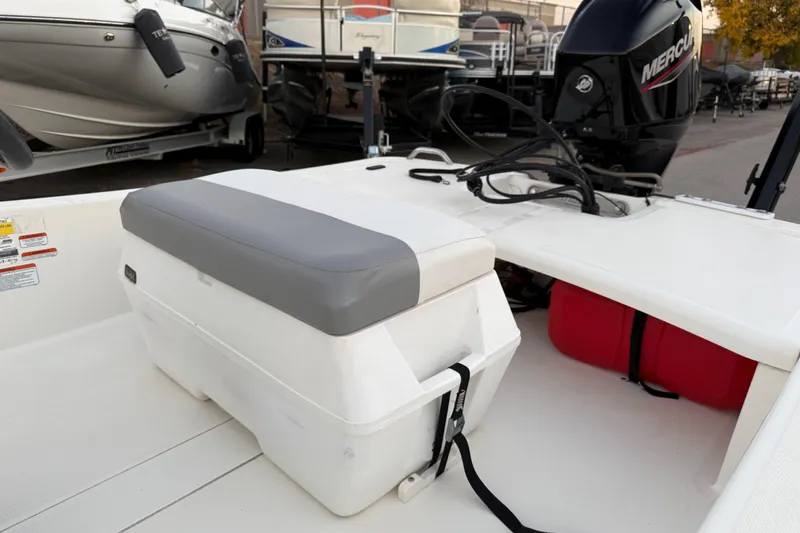 Slide: The Image of 2023 Mako Pro Skiff 15 CC boat with seating and console, displayed outdoors. - 24