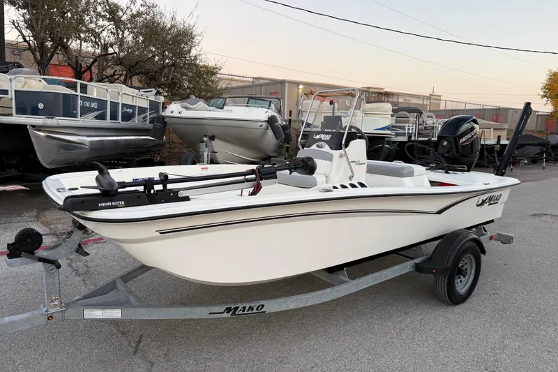 Slide: The Image of 2023 Mako Pro Skiff 15 CC boat on trailer, parked in a marina lot. - 3