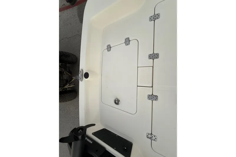 Slide: The Image of 2023 Mako Pro Skiff 15 CC boat interior with storage compartment and hinges. - 33