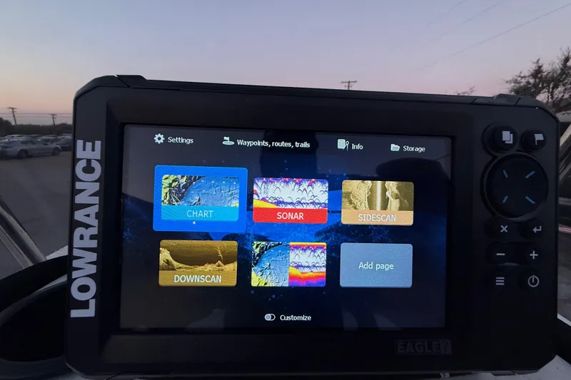 Slide: The Image of Lowrance GPS display on 2023 Mako Pro Skiff 15 CC at dusk, showing map and data. - 39