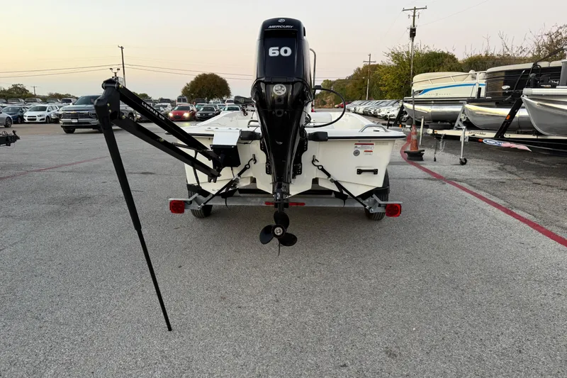 Slide: The Image of 2023 Mako Pro Skiff 15 CC with Mercury outboard motor in a boatyard. - 52