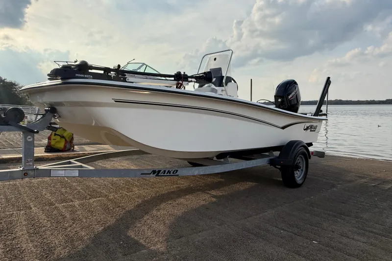 Slide: The Image of 2023 Mako Pro Skiff 15 CC on trailer by the water, ready for launch. - 56