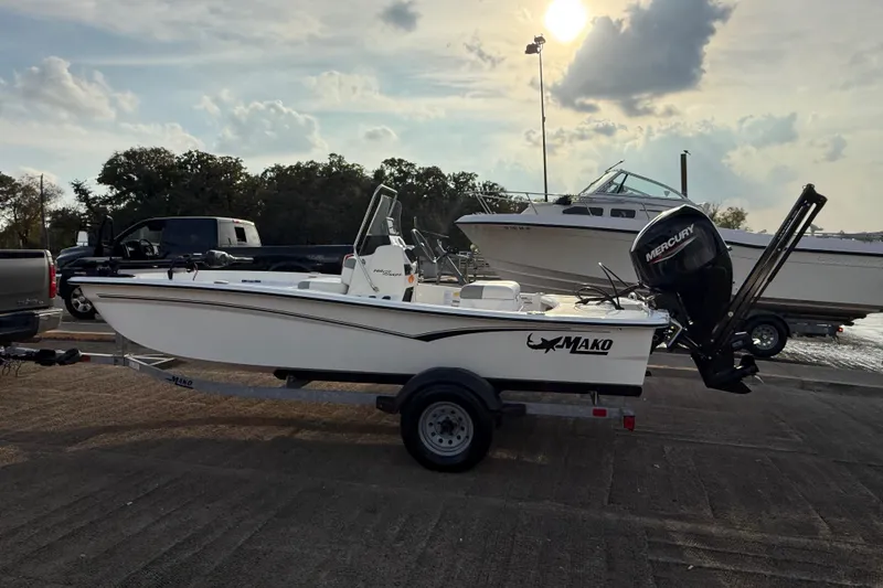 Slide: The Image of 2023 Mako Pro Skiff 15 CC boat on trailer at sunset by the water. - 59
