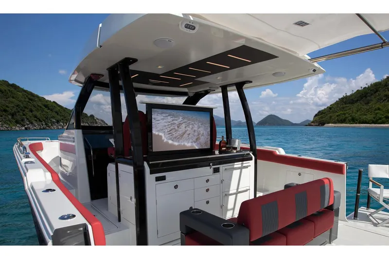 Slide: The Image of Manufacturer Provided Image: 2020 Ocean Alexander 45 Divergence Sport yacht interior with TV, red seating, and ocean view. - 11