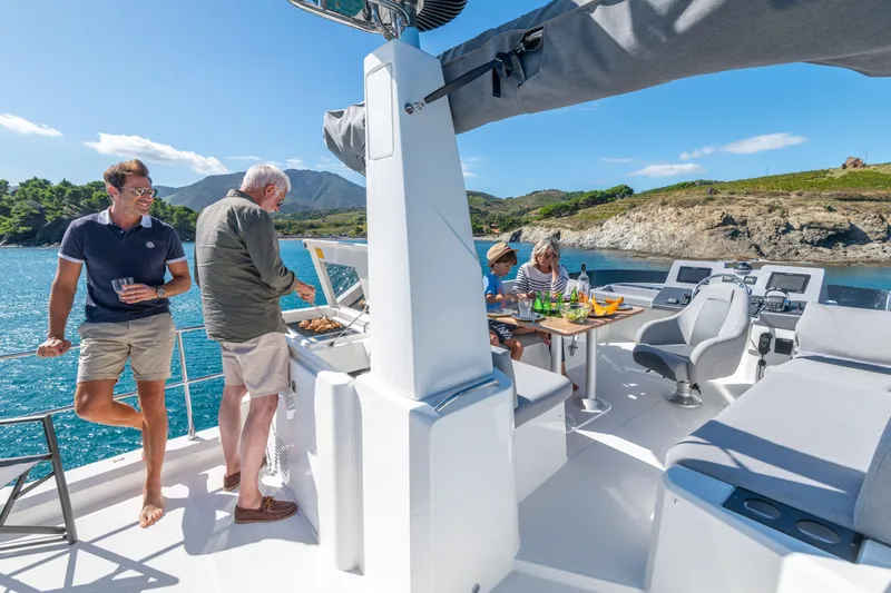 Slide: The Image of People enjoying a barbecue on a 2026 Beneteau Swift Trawler 41 Fly yacht. - 10