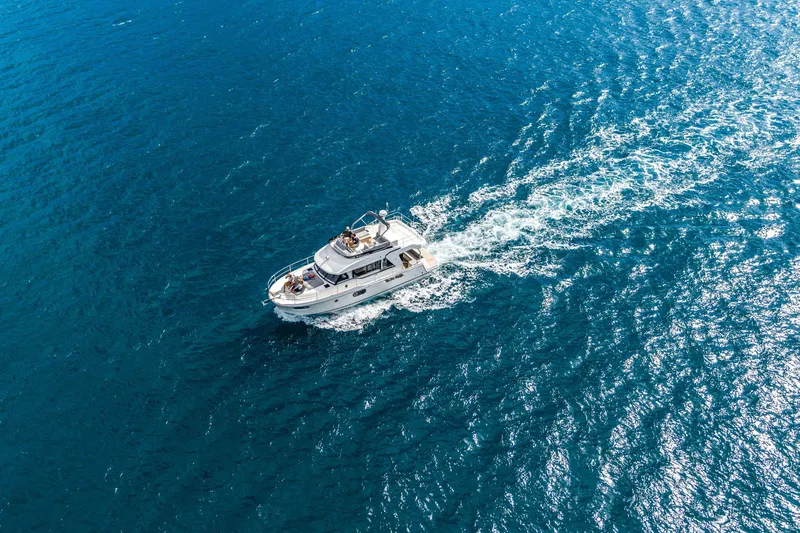 Slide: The Image of Aerial view of 2026 Beneteau Swift Trawler 41 Fly cruising on blue ocean waters. - 4