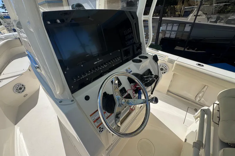 Slide: The Image of 2021 Cobia 262 Center Console boat dashboard with steering wheel and navigation controls. - 10
