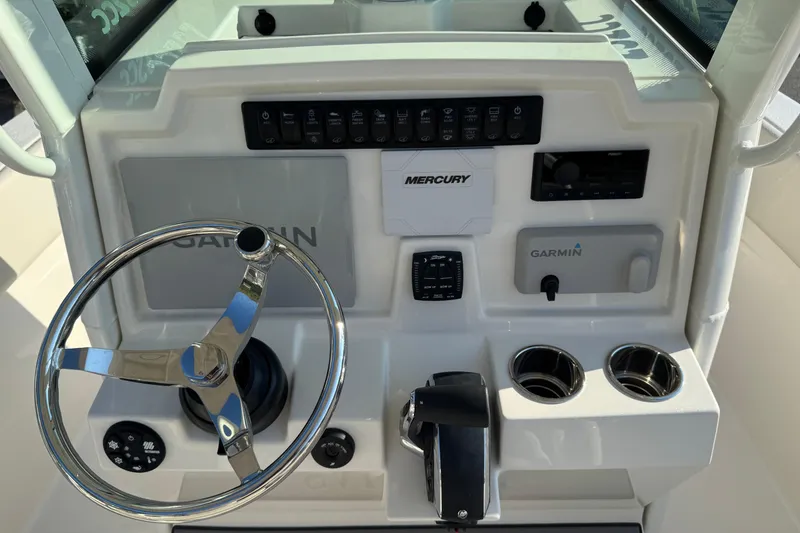 Slide: The Image of 2026 Sailfish 232 CC boat dashboard with steering wheel, Garmin and Mercury controls. - 14