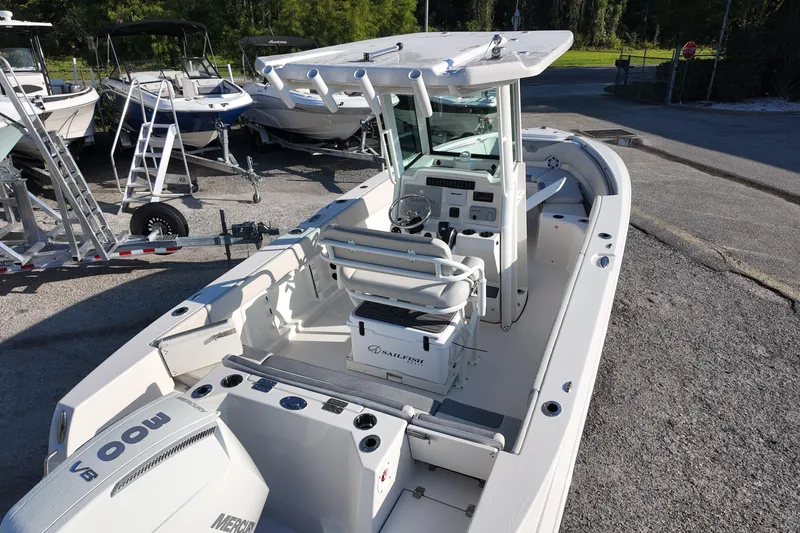 Slide: The Image of 2026 Sailfish 232 CC boat with center console and Mercury engine, parked on a trailer. - 7