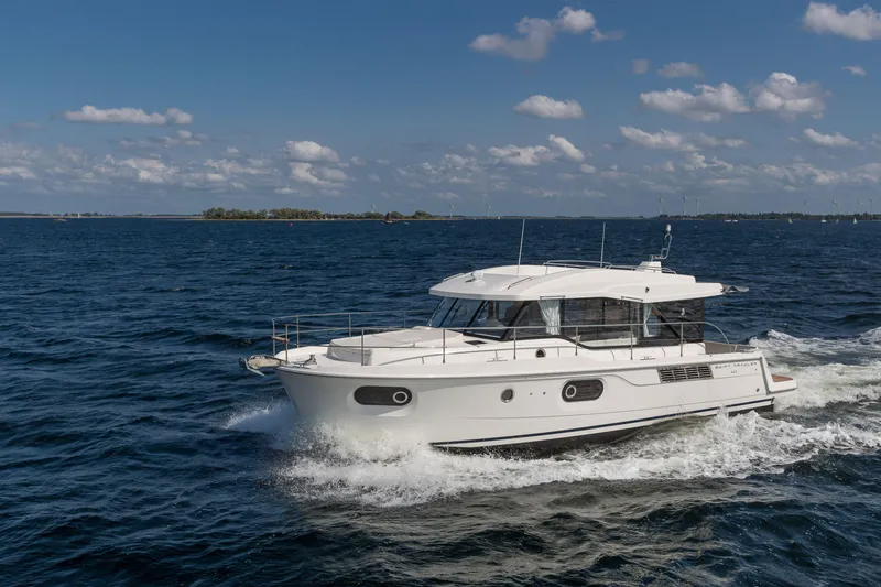 Slide: The Image of 2026 Beneteau Swift Trawler 41 Sedan cruising on open water under a clear sky. - 14