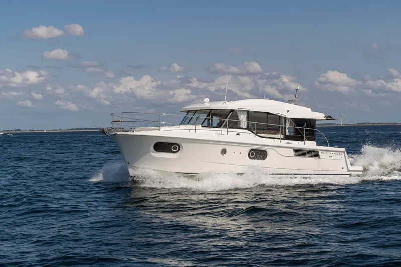 Slide: The Image of 2026 Beneteau Swift Trawler 41 Sedan cruising on open water under a clear sky. - 3