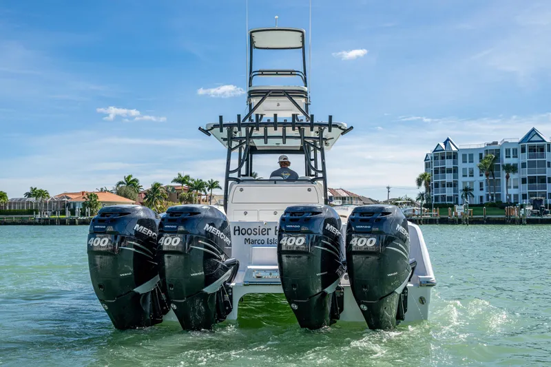 Slide: The Image of 2021 Invincible 40 Catamaran with four Mercury 400 engines on water near buildings. - 10