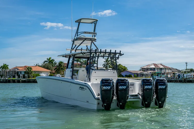 Slide: The Image of 2021 Invincible 40 Catamaran with quad engines cruising in a scenic waterfront setting. - 2
