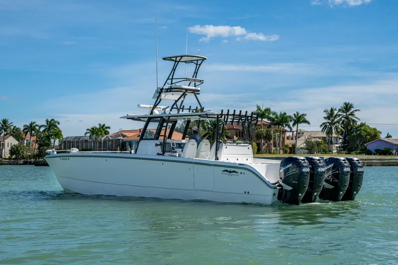 Slide: The Image of 2021 Invincible 40 Catamaran with four outboard engines on calm water, palm trees in background. - 55