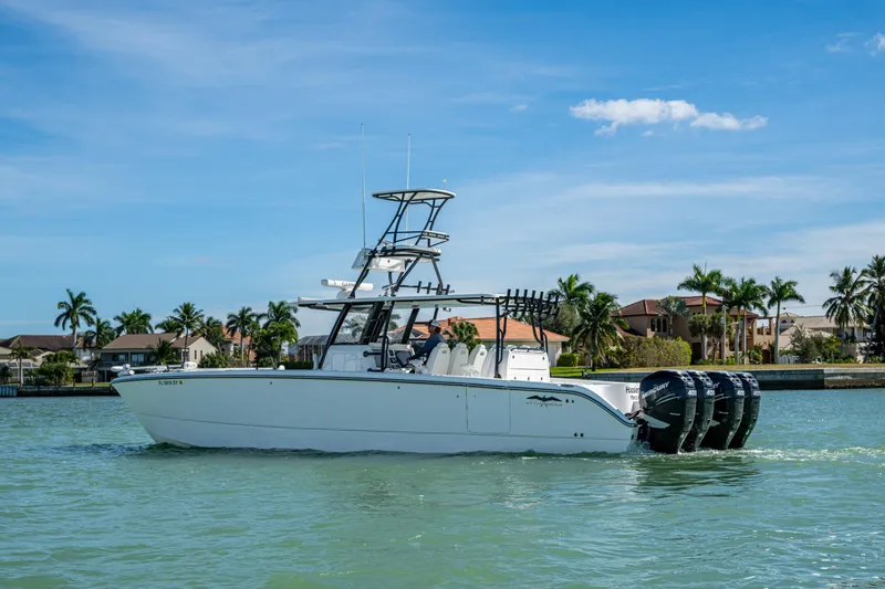 Slide: The Image of 2021 Invincible 40 Catamaran on water, featuring multiple outboard engines, with a coastal backdrop. - 57