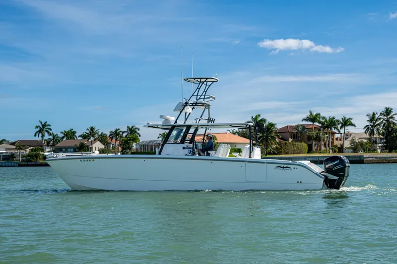 Slide: The Image of 2021 Invincible 40 Catamaran cruising on a sunny day near waterfront homes. - 59