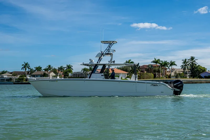 Slide: The Image of 2021 Invincible 40 Catamaran cruising on a sunny day near waterfront homes. - 60