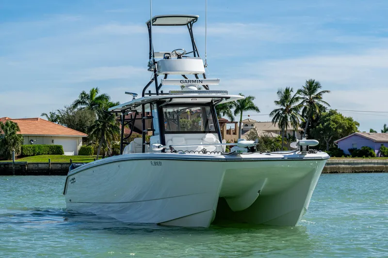 Slide: The Image of Invincible 40 Catamaran 2021 on water, with tropical background and clear skies. - 64