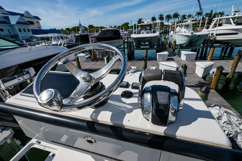 Slide: The Image of Helm of 2021 Invincible 40 Catamaran at marina, featuring steering wheel and controls. - 68