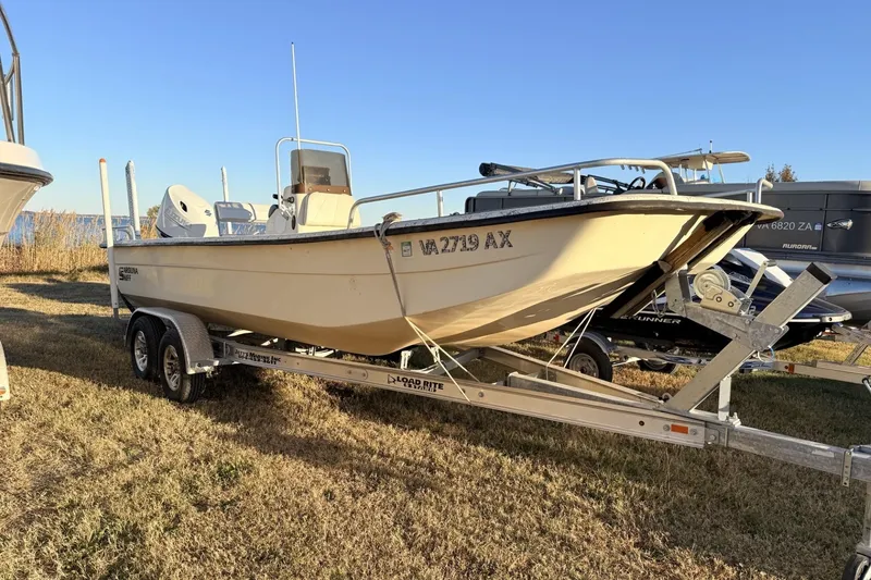 The Image of 2001 Carolina Skiff 1980 V boat on trailer, parked on grass under clear sky. - 1