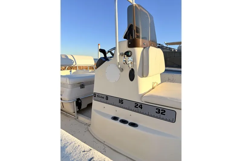 Slide: The Image of 2001 Carolina Skiff 1980 V boat interior with console and seating, under clear blue sky. - 3
