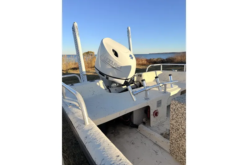 Slide: The Image of 2001 Carolina Skiff 1980 V boat with Suzuki outboard motor, near a scenic waterfront. - 4