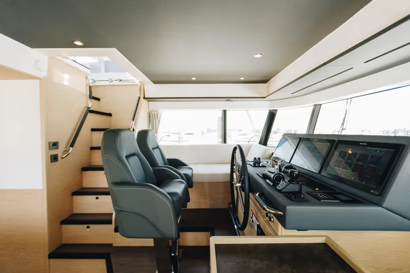 Slide: The Image of 2024 Beneteau Grand Trawler 62 helm with modern controls and luxurious seating. - 11