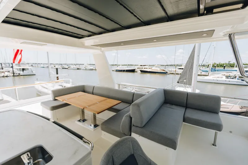 Slide: The Image of 2024 Beneteau Grand Trawler 62 yacht with spacious outdoor seating and marina view. - 14