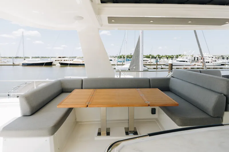 Slide: The Image of Luxurious seating area on 2024 Beneteau Grand Trawler 62 yacht, overlooking marina. - 15