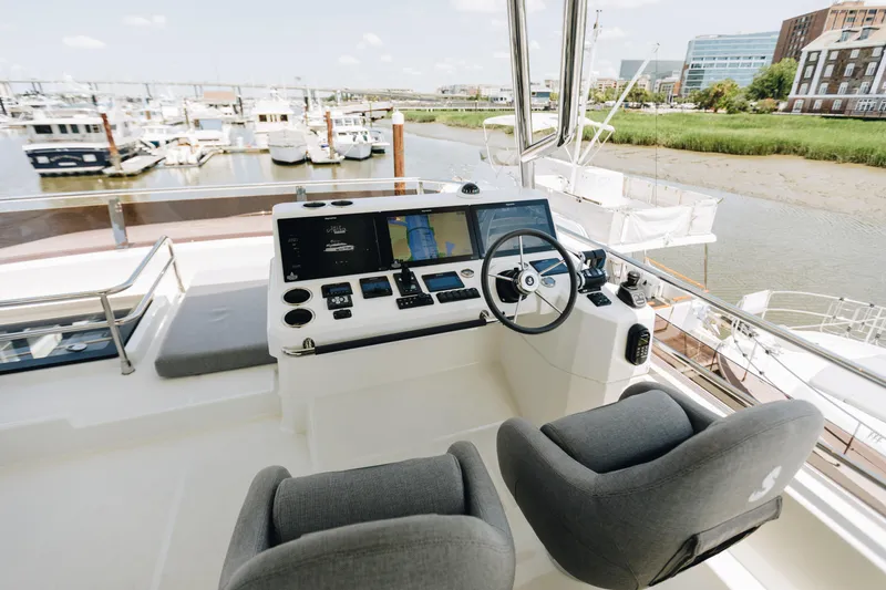Slide: The Image of 2024 Beneteau Grand Trawler 62 helm station with modern controls and dual seats. - 16
