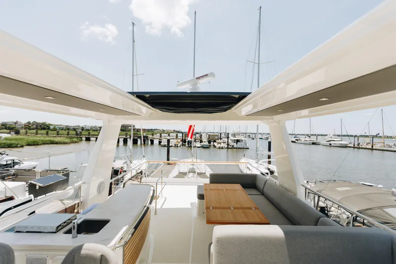 Slide: The Image of Luxurious 2024 Beneteau Grand Trawler 62 yacht interior with spacious seating and marina view. - 18