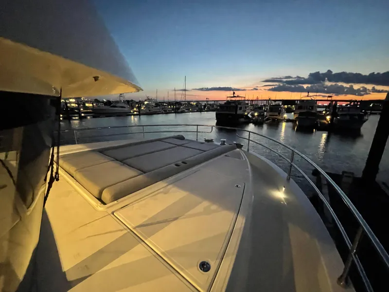 Slide: The Image of 2024 Beneteau Grand Trawler 62 at sunset, docked in a marina. - 27