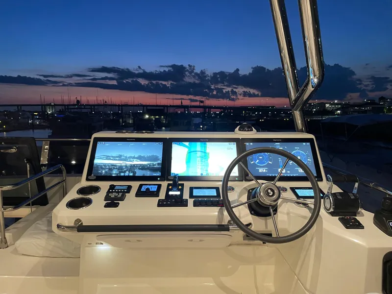 Slide: The Image of Helm of 2024 Beneteau Grand Trawler 62 at sunset, featuring advanced navigation displays. - 29